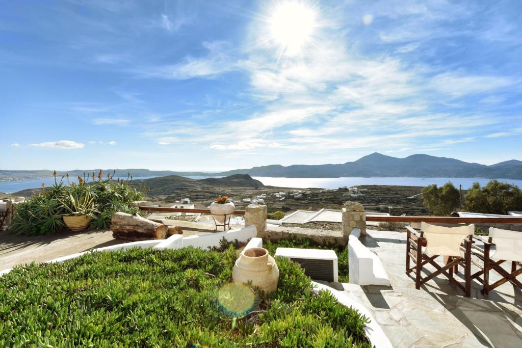 a patio with a view of the water and mountains at Anastasia's Windmill & Studio in Plaka Milou