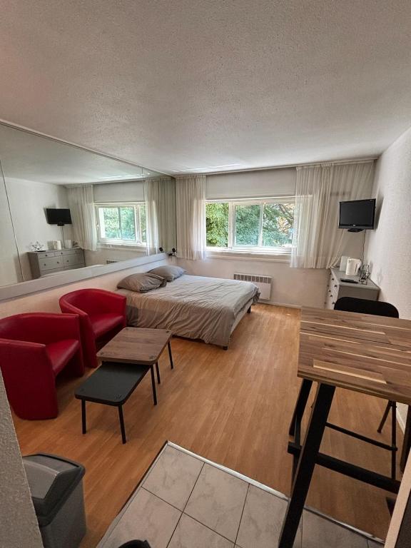 - une grande chambre avec un lit et un canapé rouge dans l'établissement Studio Carquefou, à Carquefou