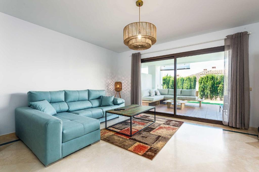 a living room with a blue couch and a table at Albatros in Casares