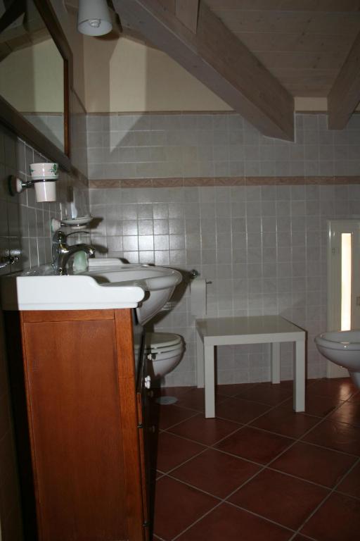 łazienka z 2 umywalkami i toaletą w obiekcie B&B Macchia d'Olmo w Capaccio-Paestum