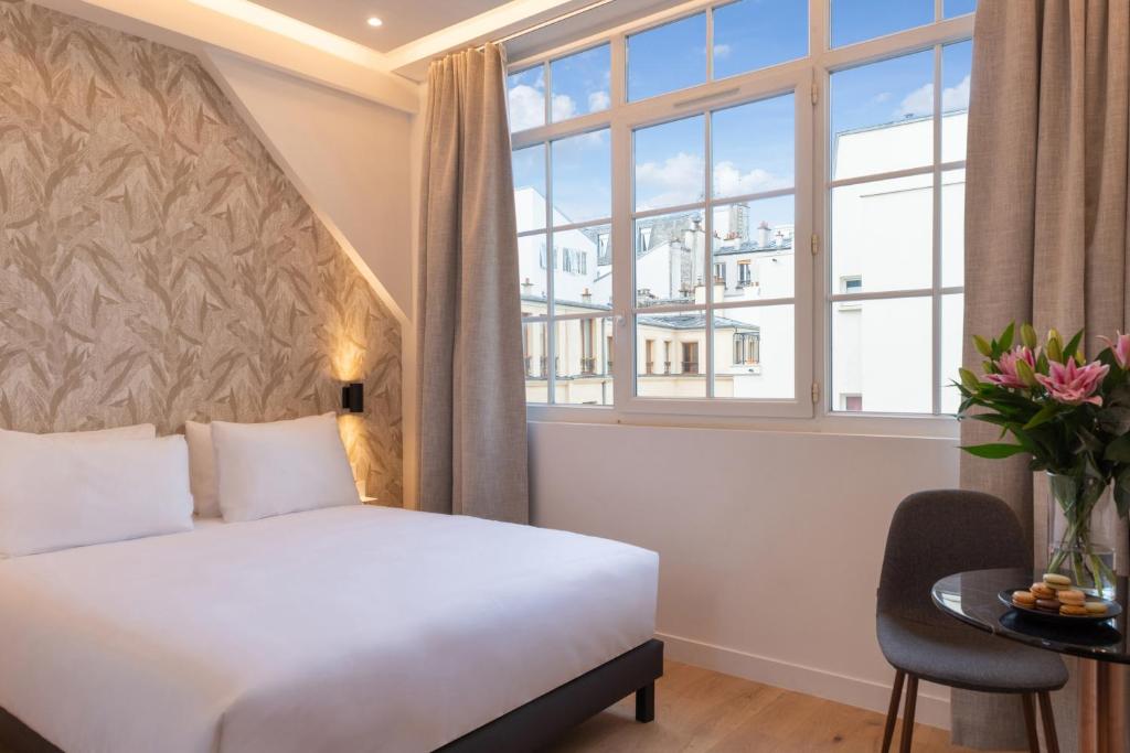 une chambre d'hôtel avec un lit et une fenêtre dans l'établissement Faubourg Station, à Paris