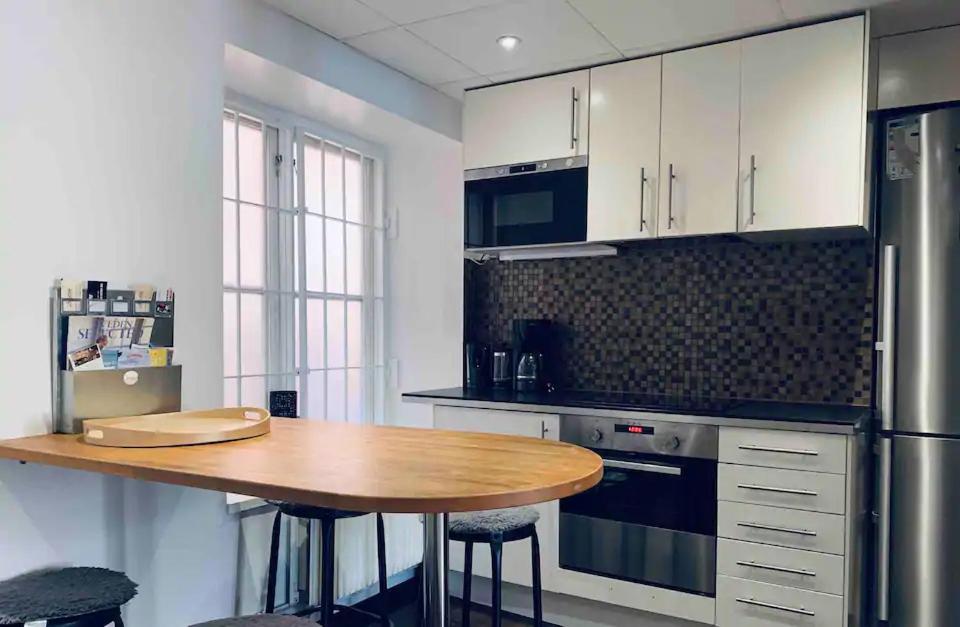 a kitchen with a wooden table and a refrigerator at Stunning Studio Old Town in Stockholm