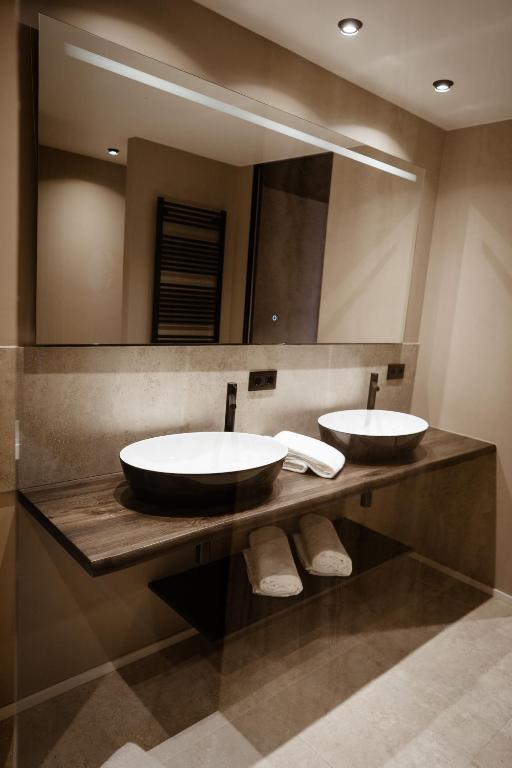 a bathroom with two sinks and a large mirror at Anatura Luxembourg in Weiswampach