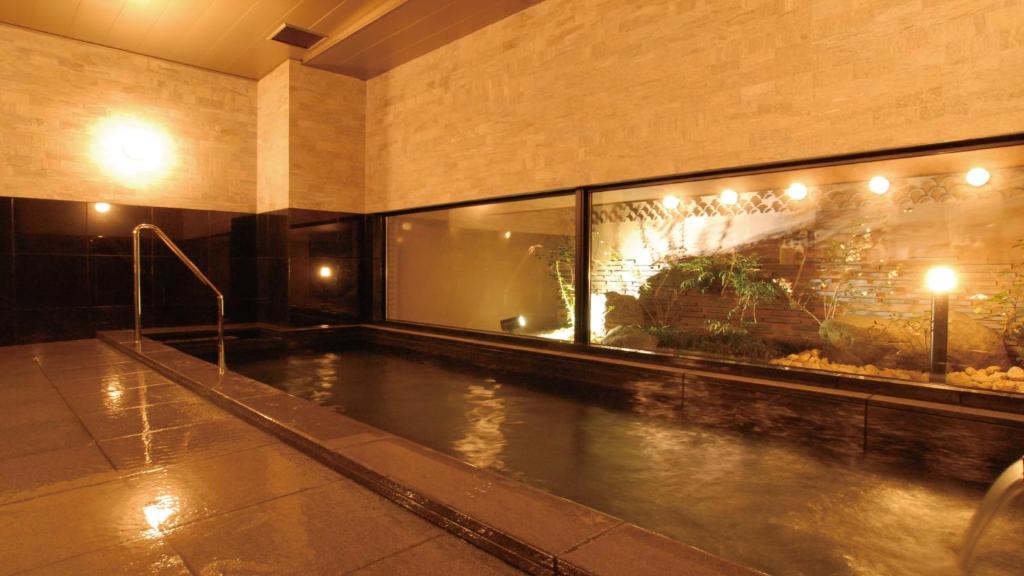 una piscina coperta in un edificio con piscina di AB Hotel Kakamigahara a Kakamigahara
