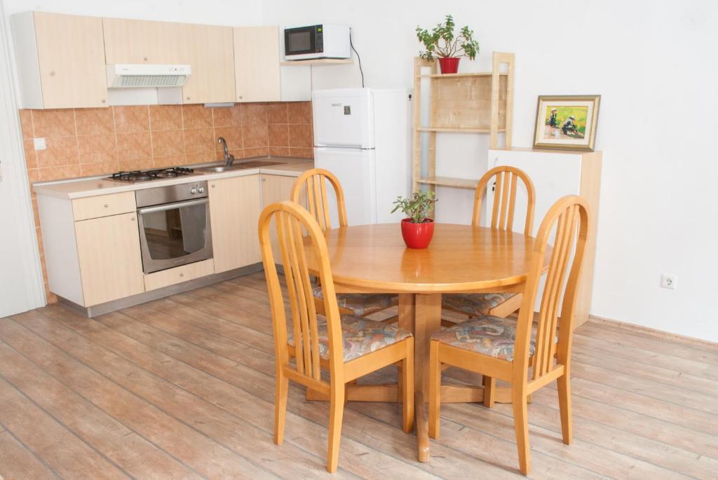Apartment Bon Voyage في ماريبور: مطبخ مع طاولة خشبية وأربع كراسي