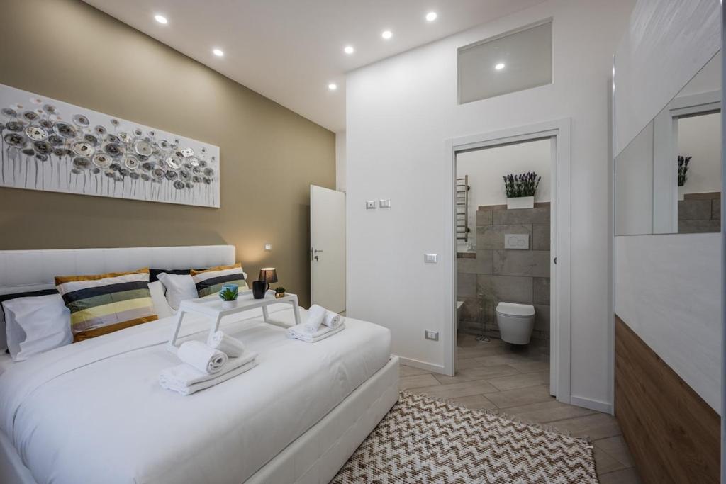 una camera da letto con un grande letto bianco e un bagno di Train Station Deluxe 3 Bath a Bologna