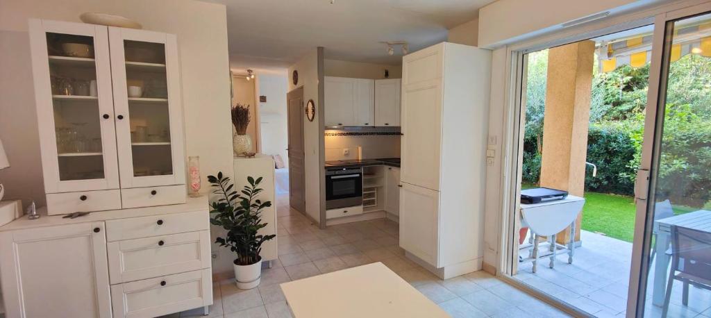 une grande cuisine avec des placards blancs et une terrasse dans l'établissement Garden studio 150 m from the beach, à Fréjus