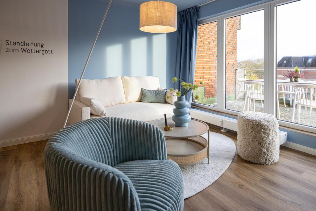 a living room with a couch and a chair and a table at Penthouse Flensburg in Flensburg