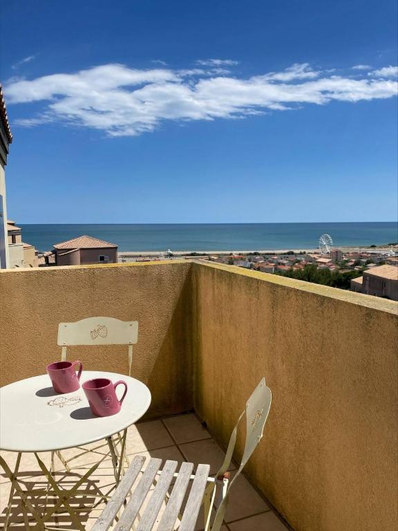 une table et des chaises sur un balcon avec vue sur l'océan dans l'établissement SP520-M344 Appartement 2 pièces SAINT PIERRE LA MER, à Saint Pierre La Mer