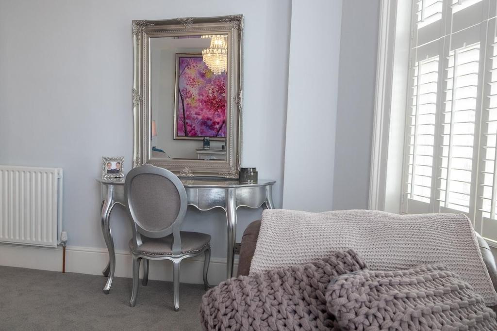 a bedroom with a table with a chair and a mirror at Beautiful Regency flat by Sea in Brighton & Hove