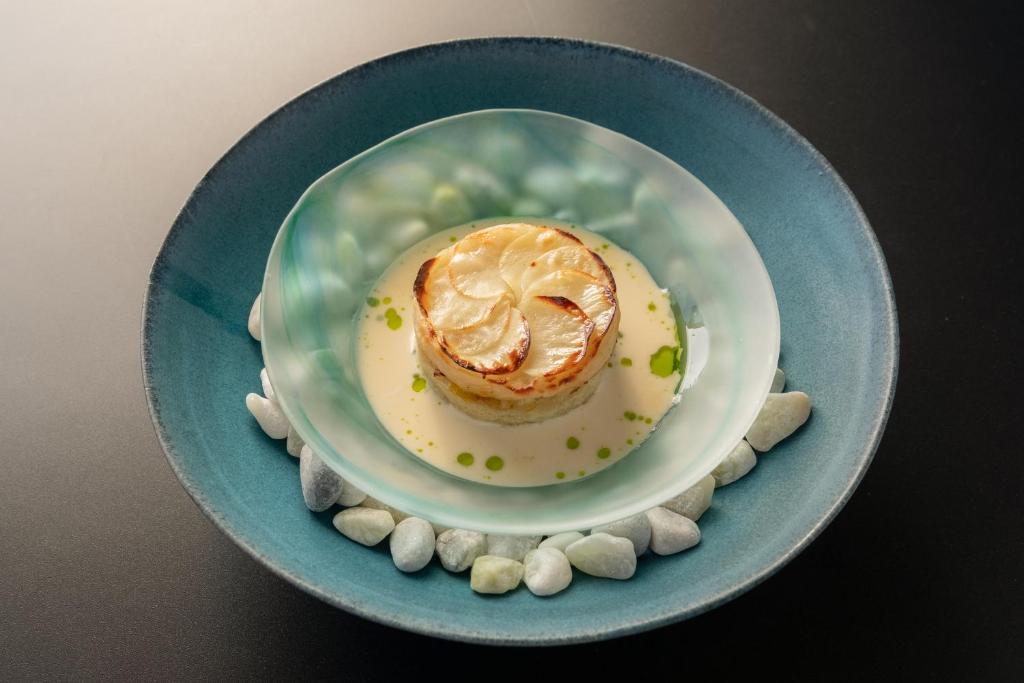 a blue plate with a pastry on a table at Mt Fuji View and Private Sauna Ryokan Shizuku in Yamanakako