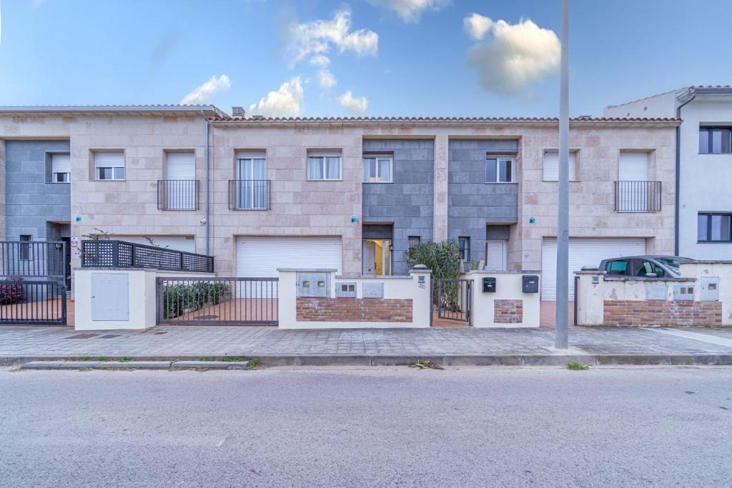 an apartment building with a fence and a street at Jouvacations Ripolles Figueres-Vilafant in Vilafant