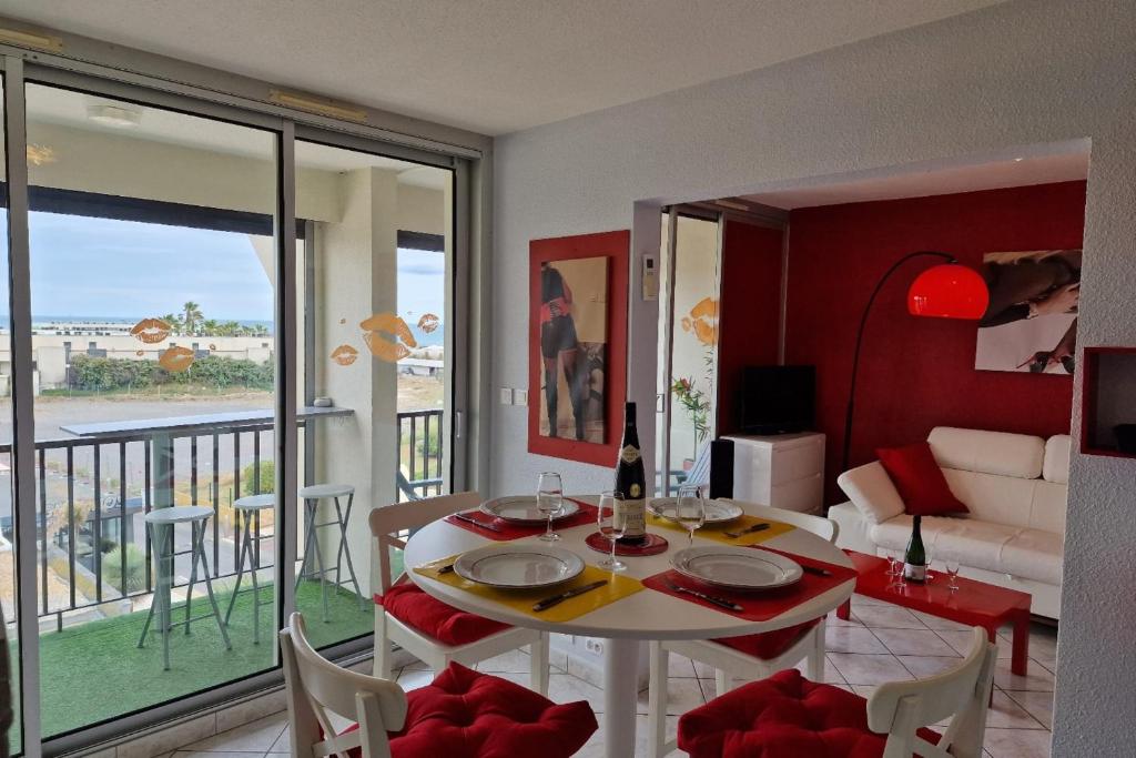 - un salon avec une table et une vue sur l'océan dans l'établissement Naturiste Cap d'Agde Héliopolis F 61, au Cap d'Agde