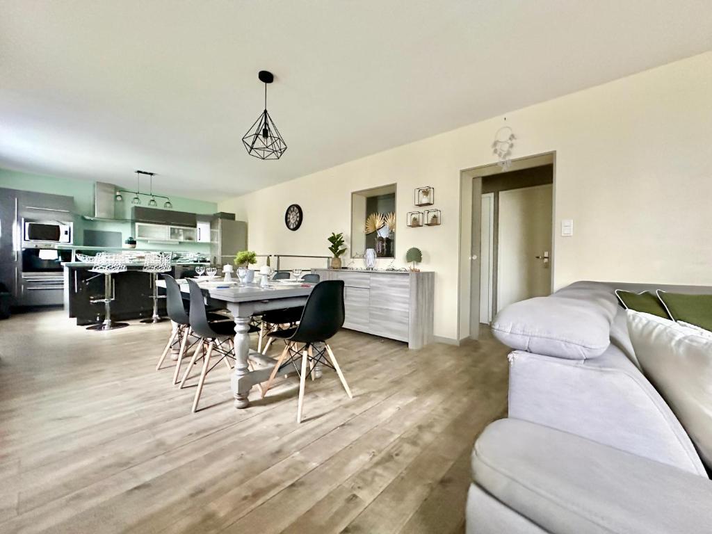 Il comprend un salon et une cuisine avec une table et des chaises. dans l'établissement Le Refuge du Palais, à Le Palais-sur-Vienne