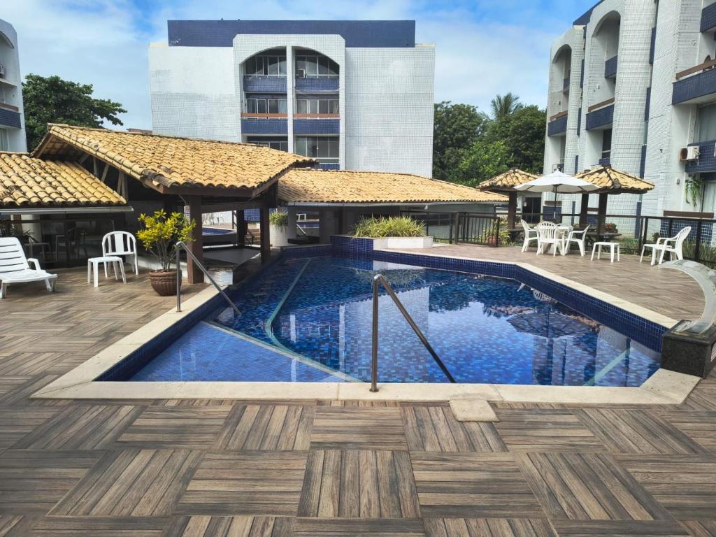 a swimming pool in front of a building at Apartamento em Vilas do Atlântico in Lauro de Freitas