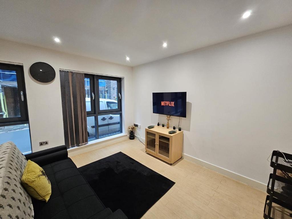 a living room with a couch and a flat screen tv at Bee Accommodations - NG1 Apartment in Nottingham