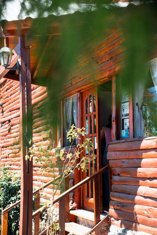 a log cabin with a porch and a door at Los Fresnos in El Calafate