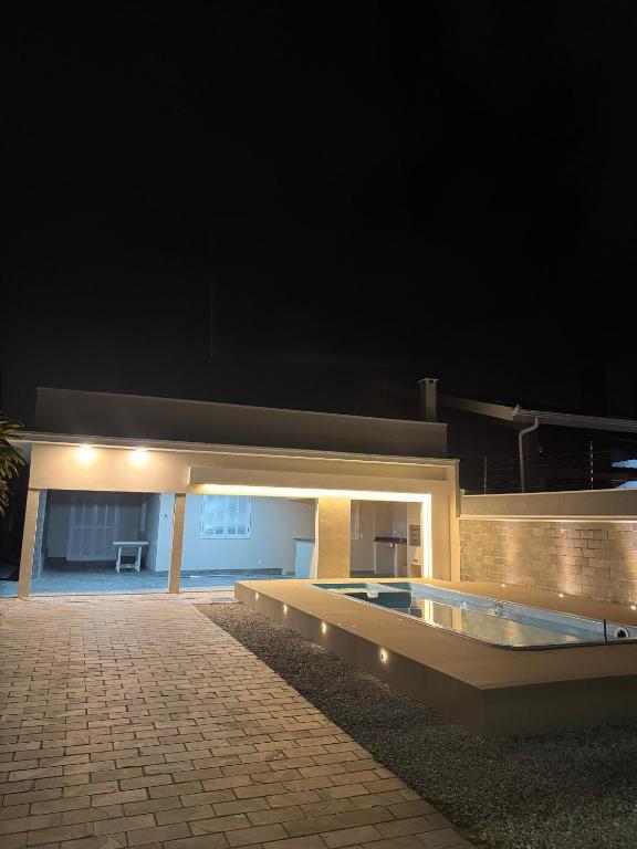 a house with a swimming pool at night at Casa 50m do mar in Matinhos