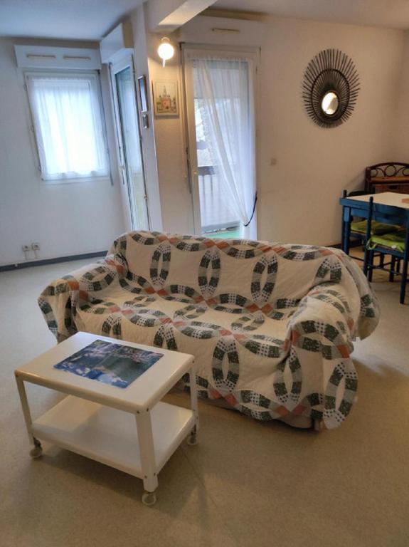 un salon avec un canapé et une table dans l'établissement Grand Studio Balcon Parking Privé Aulus les Bains, à Aulus-les-Bains