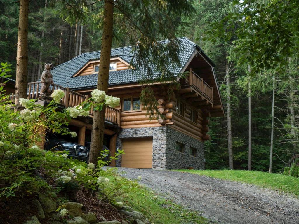 a log cabin with a garage in the woods at Wellness Zrub Durik Bystra in Horná Lehota