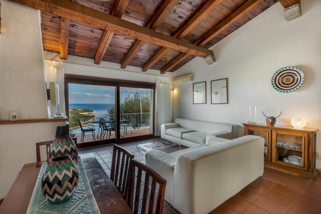 un soggiorno con divano e tavolo di Le Case di Mara - Appartamento Vista Mare a Porto Rotondo a Porto Rotondo