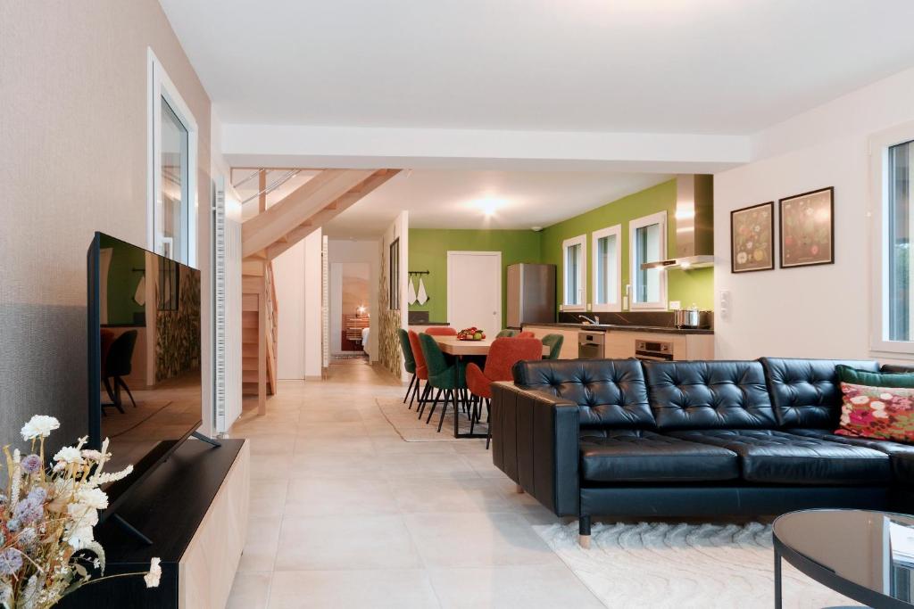 un salon avec un canapé et une salle à manger dans l'établissement Le Logis de la Vicomté - Maison proche plage, à Dinard