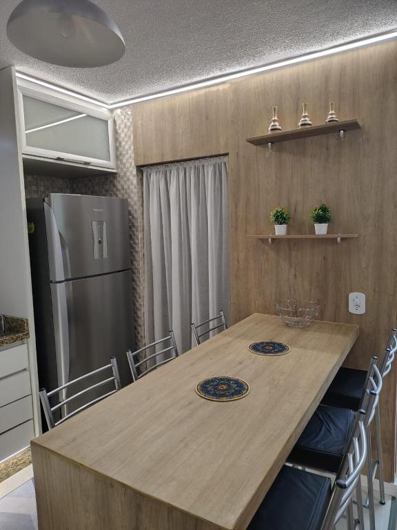 a kitchen with a table with chairs and a refrigerator at B&B Conforto próximo ao Aeroporto in São José dos Pinhais