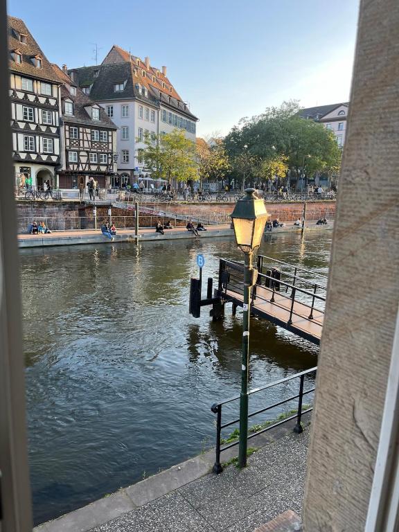 un feu de rue à côté d'une rivière avec des bâtiments dans l'établissement À la belle étoile, à Strasbourg