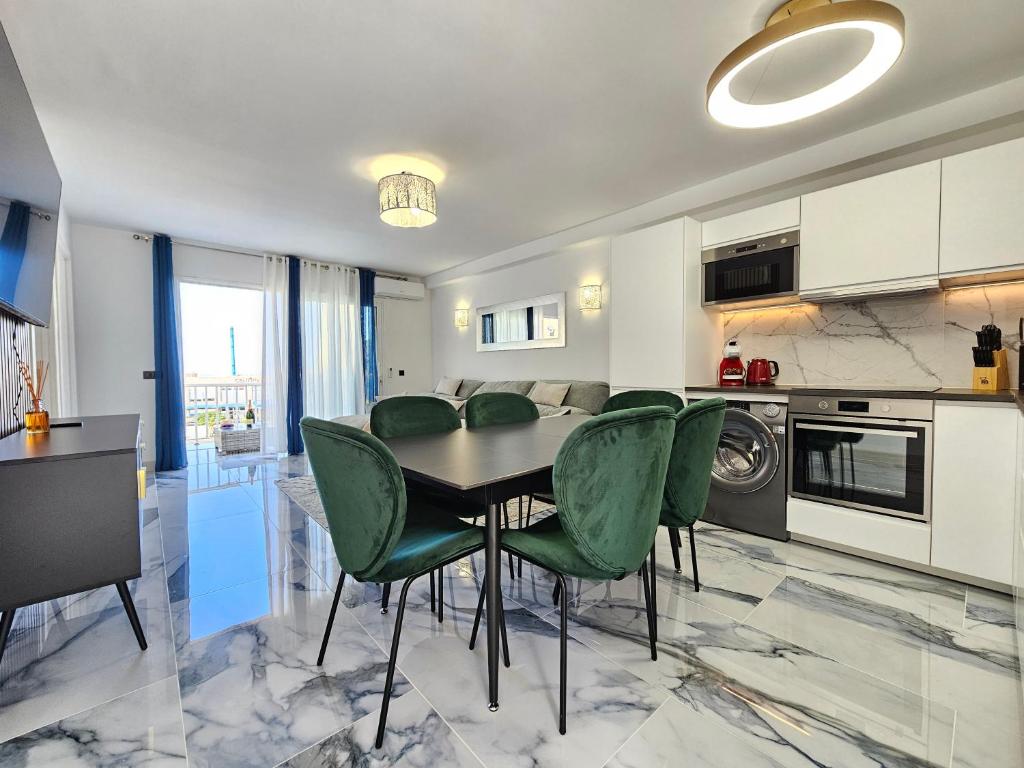 a kitchen and dining room with a table and green chairs at Mareverde Dream in Costa de Adeje