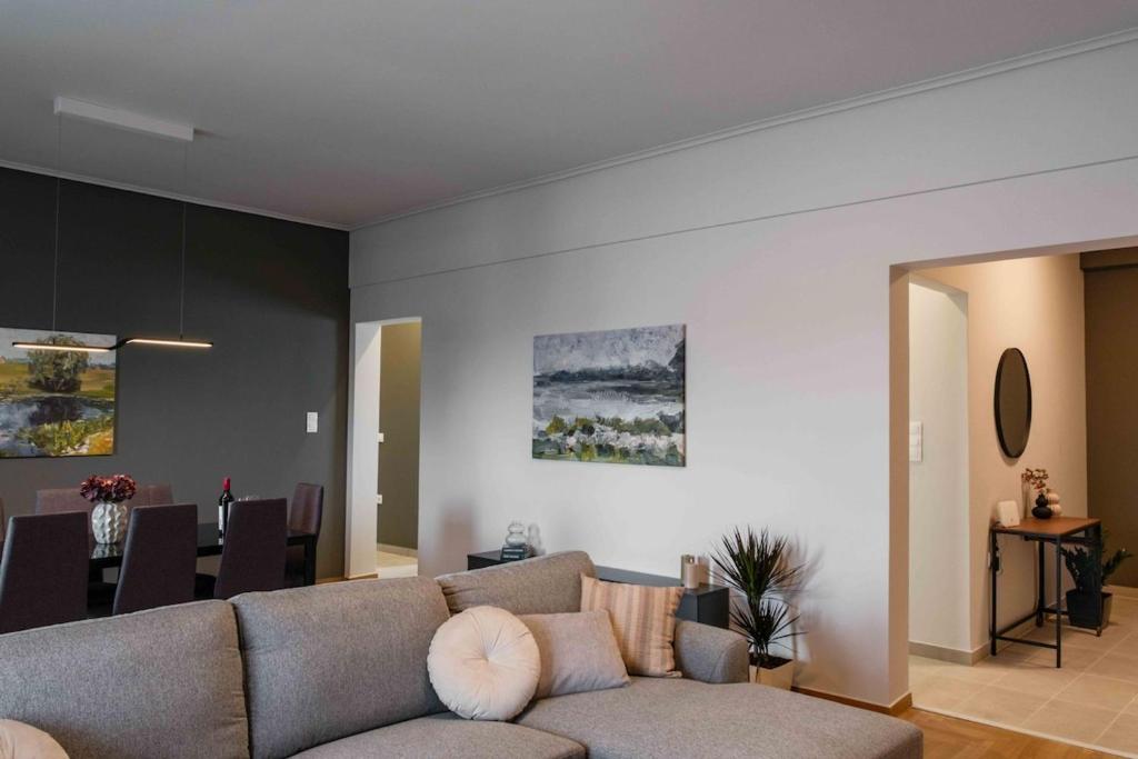 a living room with a couch and a dining room at Spacious seaside flat at alimos in Athens
