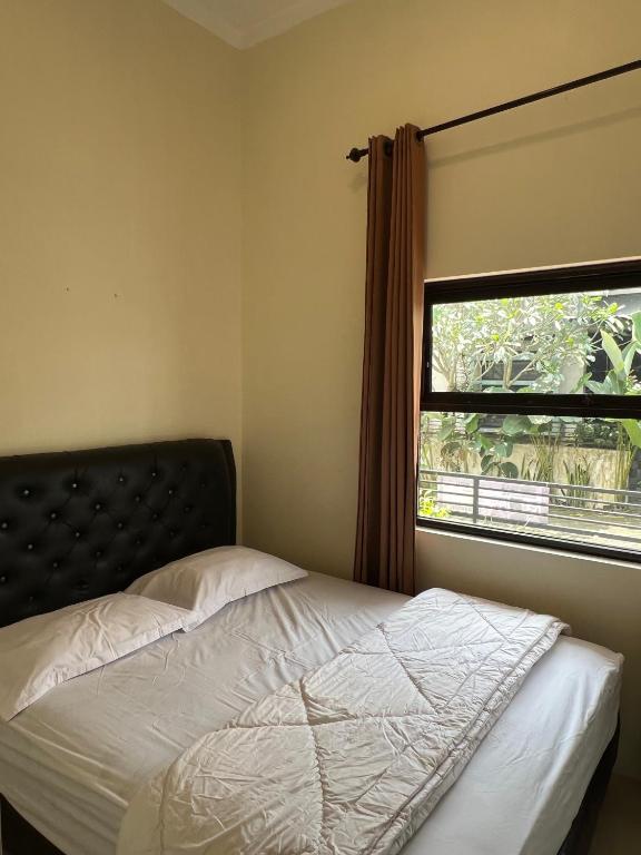 a bedroom with a bed and a window at Jojo's Villa Batu in Batu