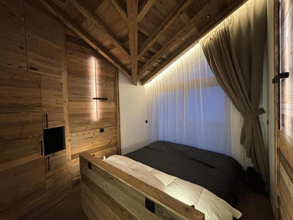 Un dormitorio con una cama en una habitación de madera. en Luxury Property Paradiski incl Swim Pool I Sauna I Hammam, en Peisey-Nancroix