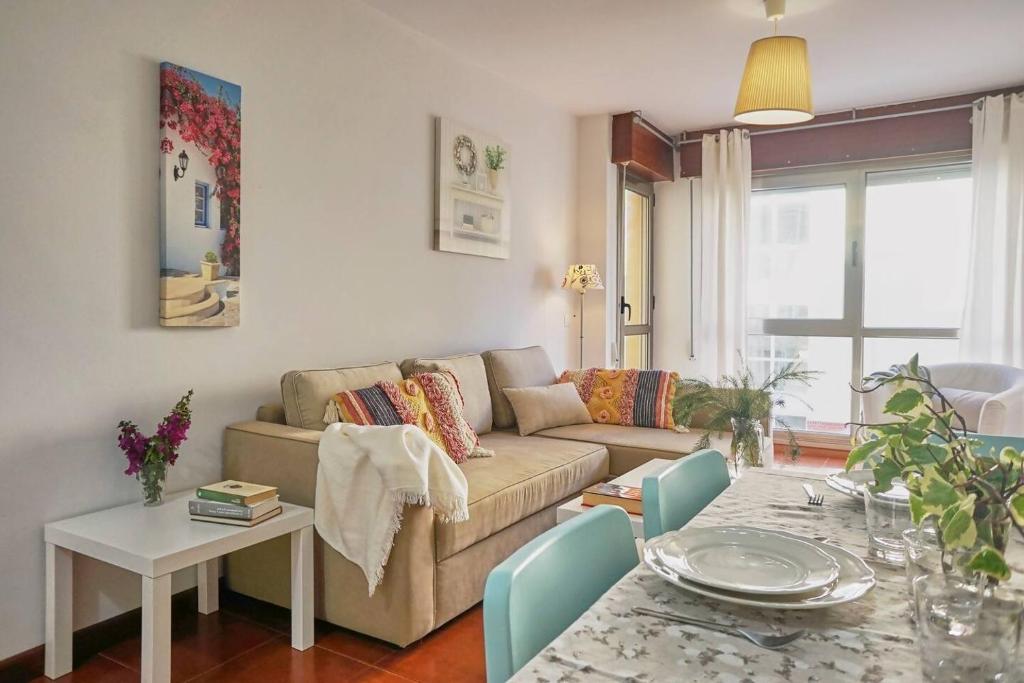 een woonkamer met een bank en een tafel bij FGDR342E La Playona in San Vicente de la Barquera