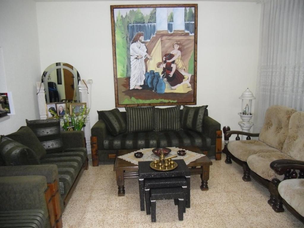 a living room with a couch and a table at Cana Wedding Guest House in Kafr Kannā