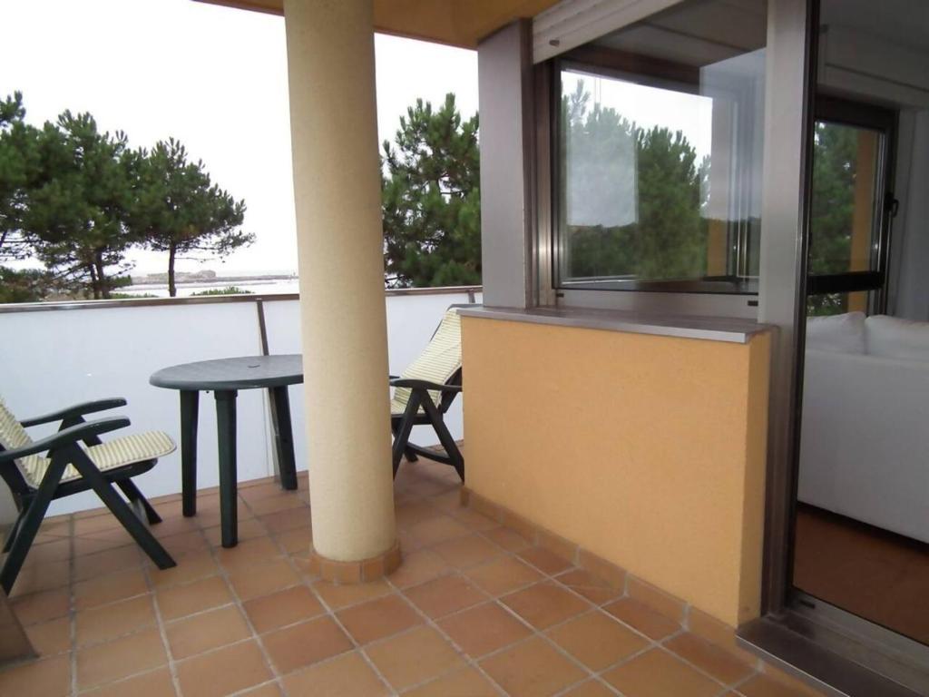 a balcony with a table and chairs and windows at FGDR343E Las dunas in San Vicente de la Barquera