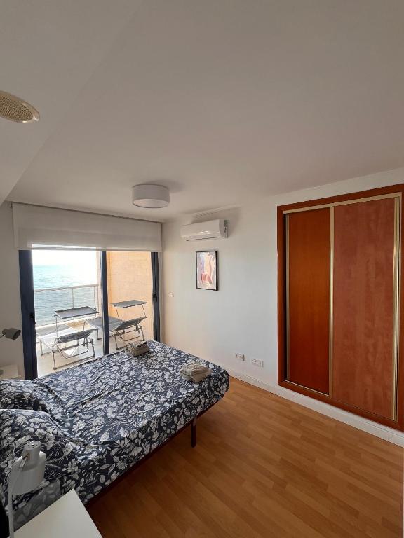 a bedroom with a bed and a sliding glass door at Apartamento en Altea con vistas al mar in Altea