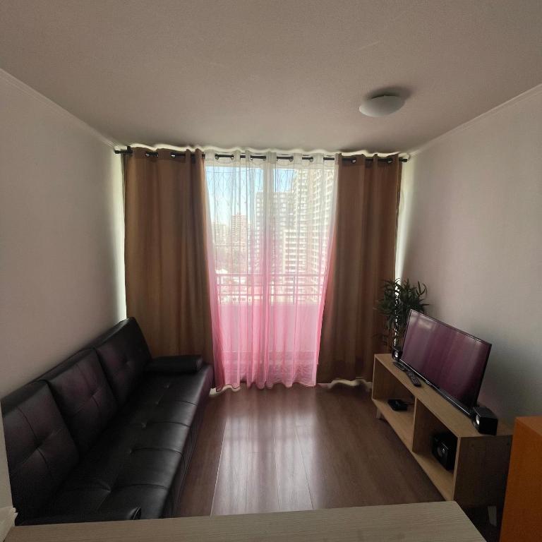 a living room with a couch and a television at Pauwla in Santiago