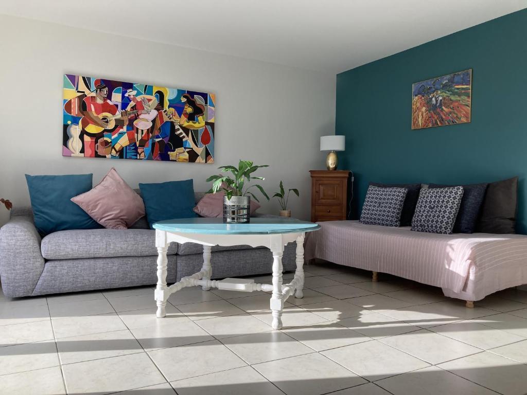 a living room with a couch and a table at Maison non fumeur - jardin 5 personnes proche des plages finistériennes in Guipavas