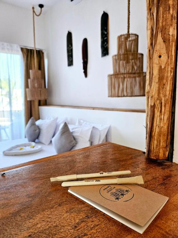 a wooden table with two chopsticks on top of it at Mfumbwi Twins Apartments in Jambiani
