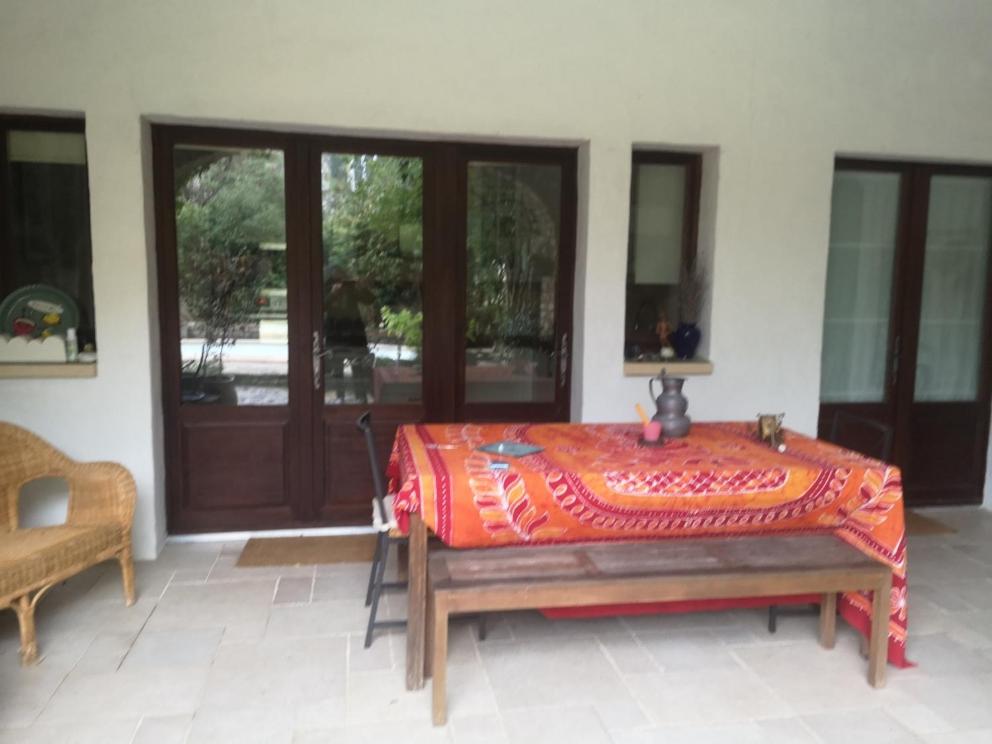 une chambre avec une table devant une porte dans l'établissement Chambre indépendante avec salle de bains et cuisine, à Aubussargues