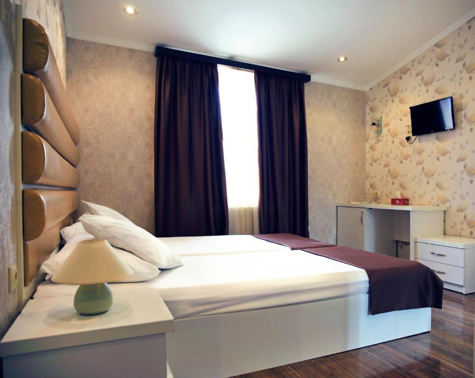 a bedroom with a large bed with a window at Rondo Hotel in Tbilisi City