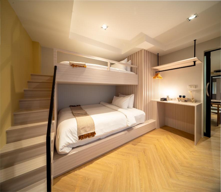 a bedroom with bunk beds and a staircase at Triple Four in Bangkok