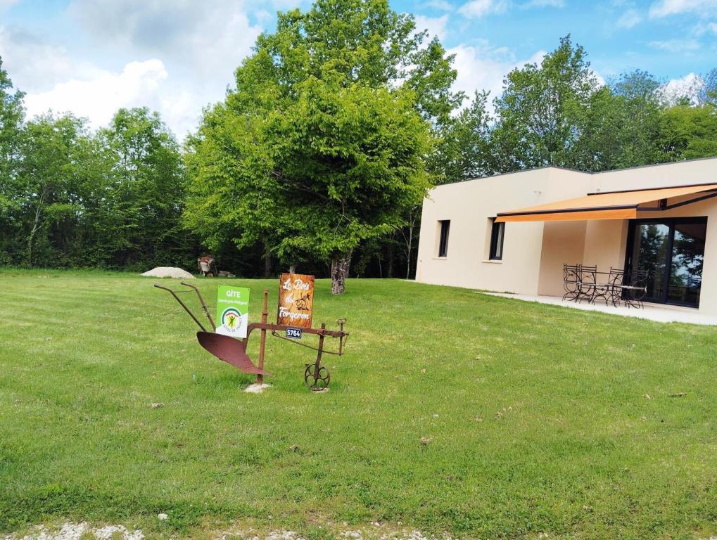 une cour avec un bâtiment et une table dans l'herbe dans l'établissement Le bois du forgeron, à Sarlat-la-Canéda