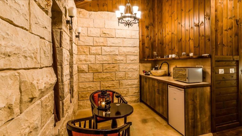 a kitchen with a counter and a table in a room at Gilad Cabins in Odem