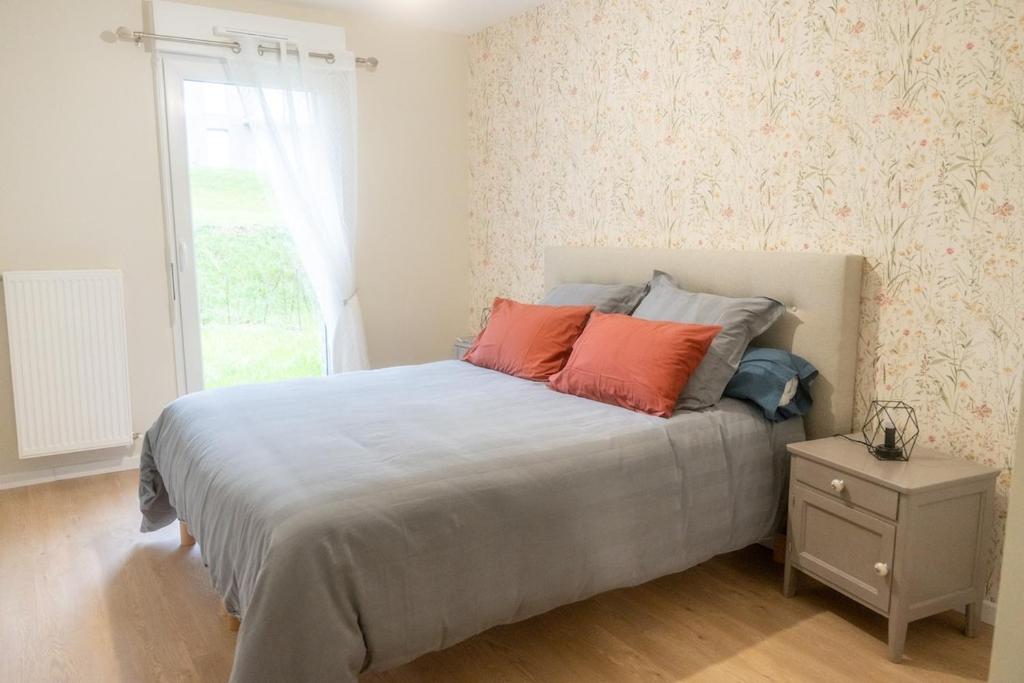 - une chambre dotée d'un lit avec des oreillers orange et bleu dans l'établissement 3 04 appartement avec jardin et parking privé, à Pinchefalise