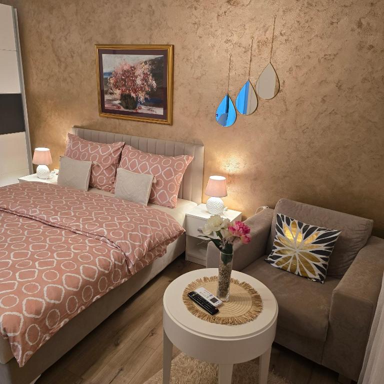 a bedroom with a bed and a couch and a table at Apartman Hersek Mostar in Mostar
