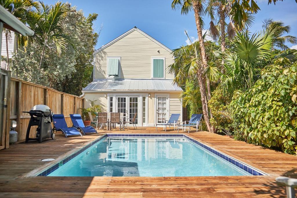 a swimming pool with a deck and a house at Jasmine Place in Key West