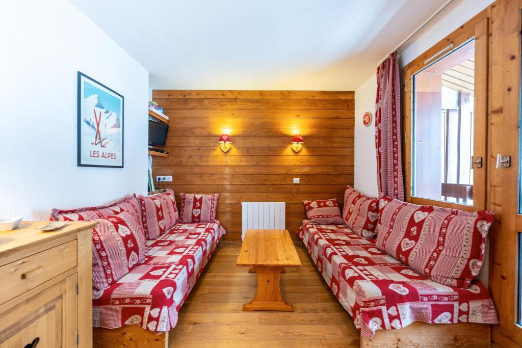 une chambre avec des canapés rouges et une table dans l'établissement Lauziere dessus 50, à Valmorel