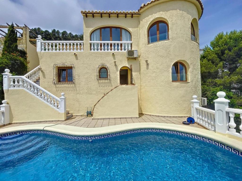 une maison avec une piscine devant dans l'établissement Villa Maravista - Luxury Villa with Private Pool and Sea View, à Benitachell