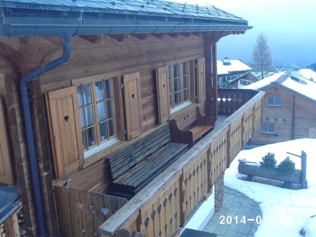 a log cabin with a porch in the snow at Chalet Heinzenberg in Urmein